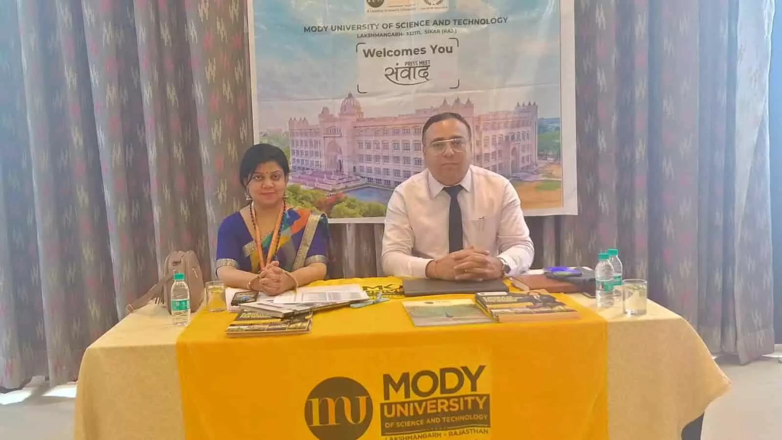 कोटा के एक होटल में मोदी यूनिवर्सिटी की प्रेस वार्ता के दौरान मेज पर बैठे दो विश्वविद्यालय प्रतिनिधि। कोटा के एक होटल में मोदी यूनिवर्सिटी की प्रेस वार्ता के दौरान मेज पर बैठे दो विश्वविद्यालय प्रतिनिधि।