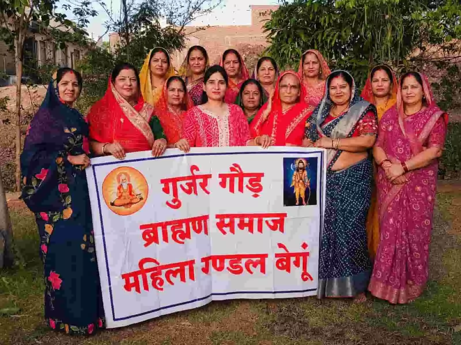 गुर्जर गौड़ ब्राह्मण समाज महिला मंडल बेगूं का बैनर थामे खड़ीं महिलाएं। गुर्जर गौड़ ब्राह्मण समाज महिला मंडल बेगूं का बैनर थामे खड़ीं महिलाएं।