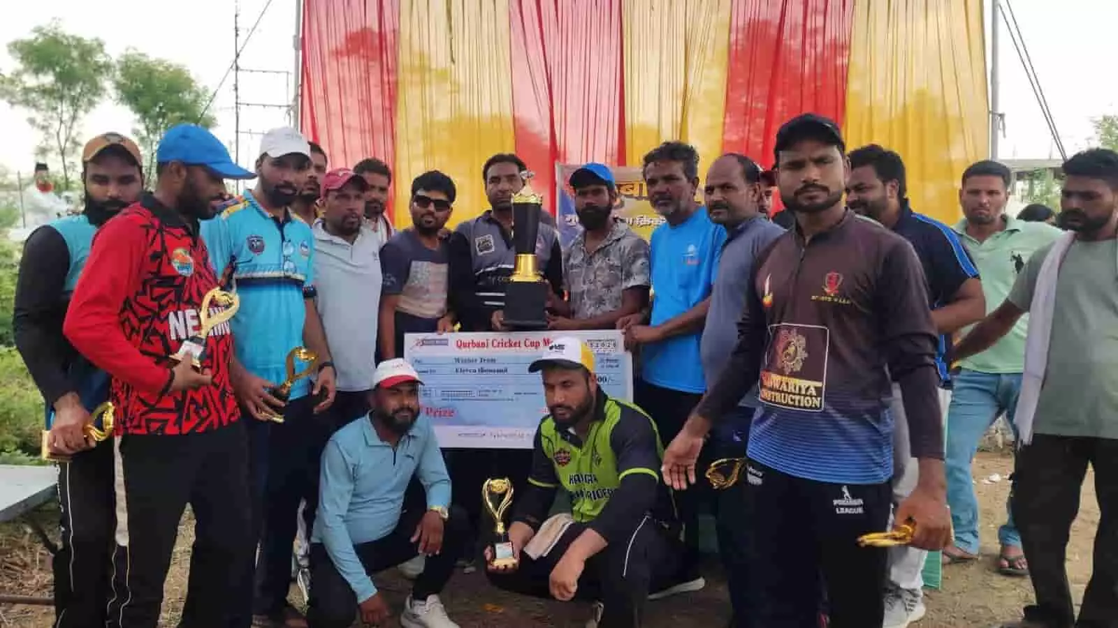 क्रिकेट मैदान पर ट्रॉफी और चेक के साथ खड़े विजेता खिलाड़ी मावली में कुर्बानी कप समापन समारोह के दौरान। क्रिकेट मैदान पर ट्रॉफी और चेक के साथ खड़े विजेता खिलाड़ी मावली में कुर्बानी कप समापन समारोह के दौरान।