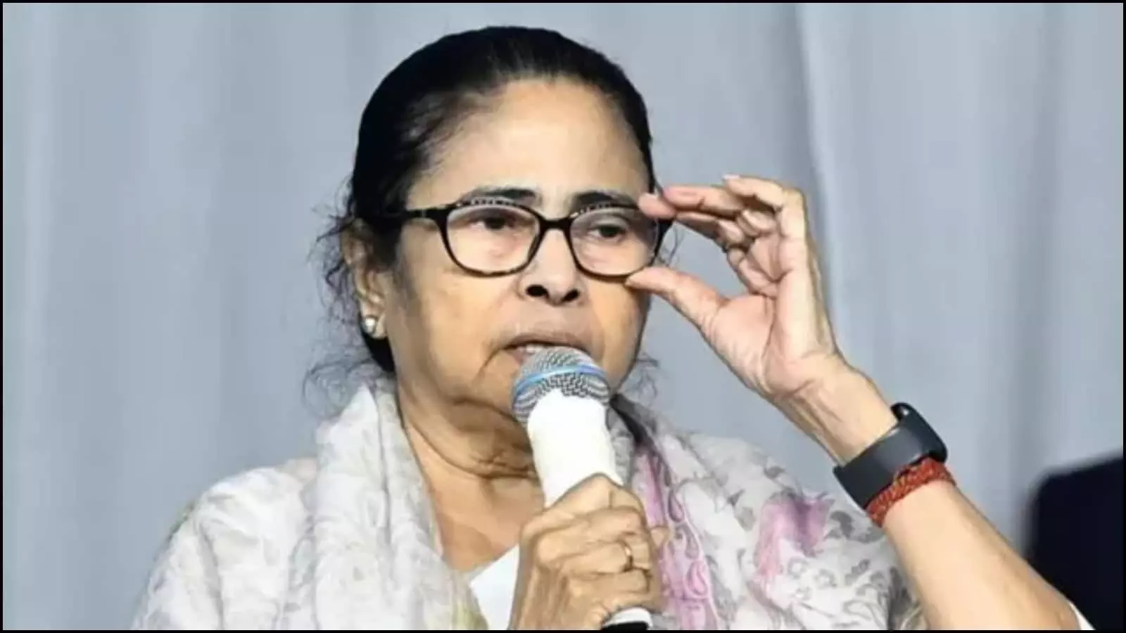 प्रेस कॉन्फ्रेंस में माइक थामे और चश्मा ठीक करते हुए मुख्यमंत्री ममता बनर्जी कोलकाता में राजनीतिक घटनाक्रम के संदर्भ में दिख रही हैं।