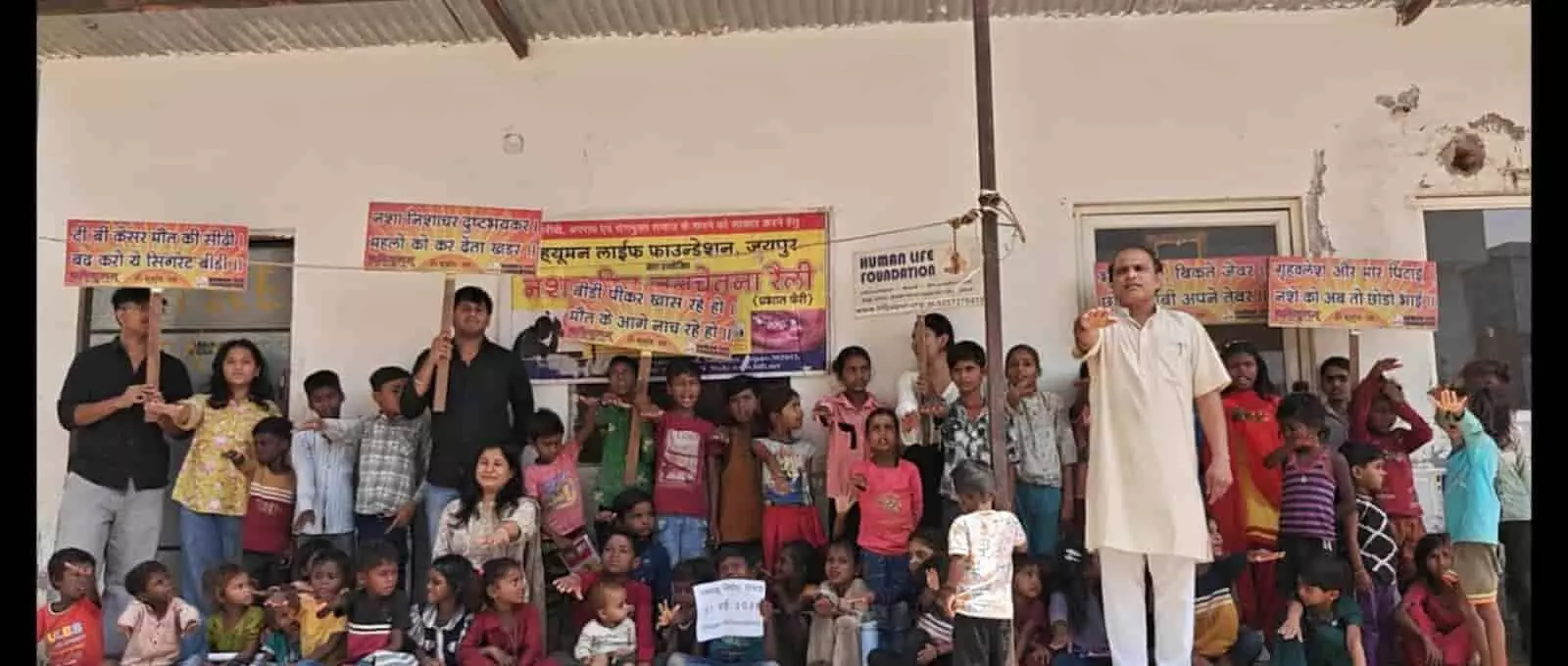 बैनर और स्लोगन पट्टिकाओं के सामने खड़े बच्चे और जागरूककर्ता जयपुर में तंबाकू निषेध का संकल्प ले रहे हैं। बैनर और स्लोगन पट्टिकाओं के सामने खड़े बच्चे और जागरूककर्ता जयपुर में तंबाकू निषेध का संकल्प ले रहे हैं।