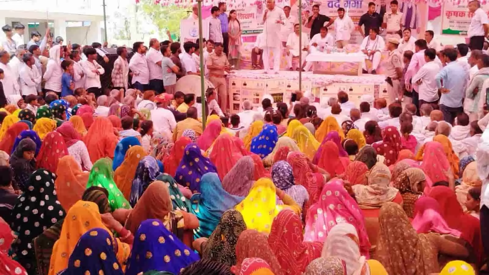 जनसभा में मंच से भाषण देते जिला कलक्टर काना राम और सामने जमीन पर बैठी ग्रामीण महिलाओं की भीड़। जनसभा में मंच से भाषण देते जिला कलक्टर काना राम और सामने जमीन पर बैठी ग्रामीण महिलाओं की भीड़।
