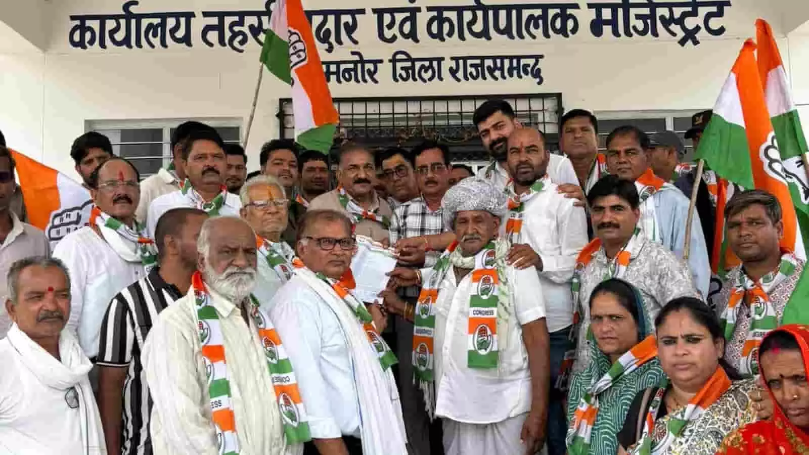 खमनोर तहसील कार्यालय के सामने कांग्रेस पार्टी के झंडे और दुपट्टे पहने हुए प्रदर्शनकारी कार्यकर्ता खड़े हैं। खमनोर तहसील कार्यालय के सामने कांग्रेस पार्टी के झंडे और दुपट्टे पहने हुए प्रदर्शनकारी कार्यकर्ता खड़े हैं।