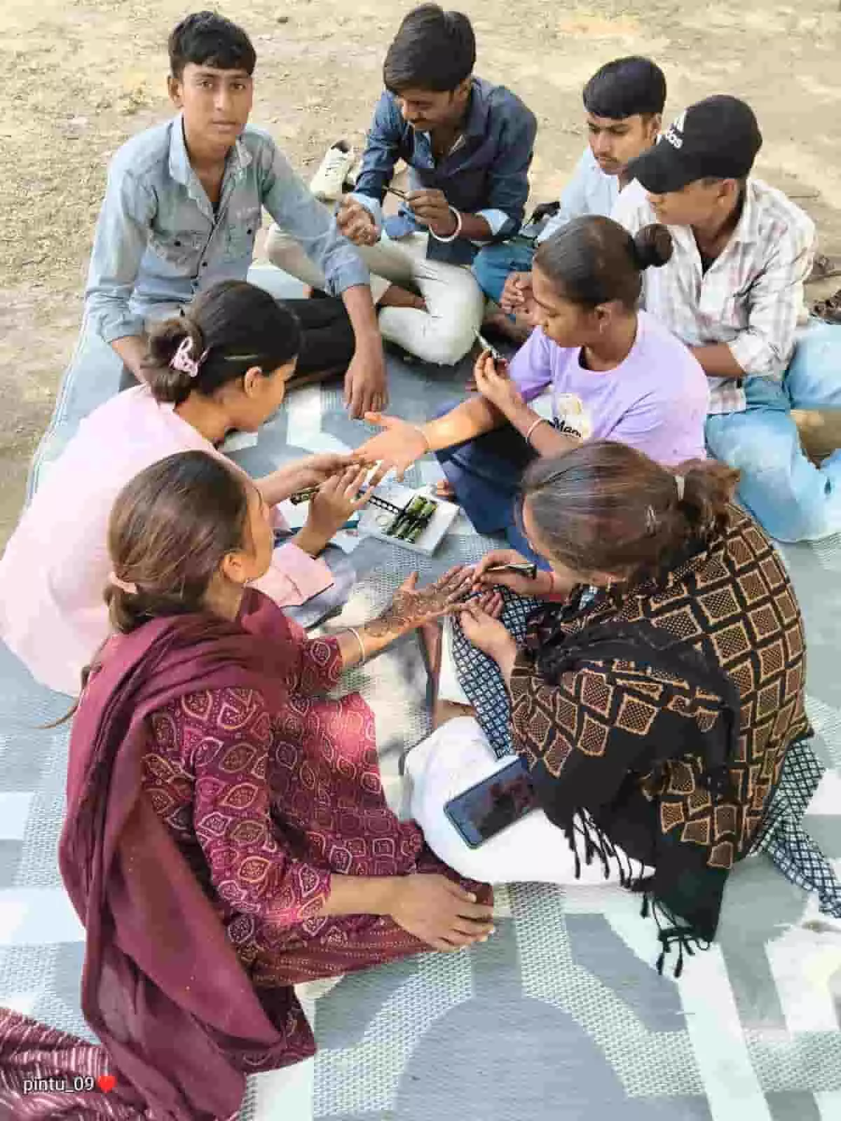 चटाई पर बैठकर एक-दूसरे के हाथों में मेहंदी लगाती छात्राएं और हुनर सीखते विद्यार्थी उदयपुर के शिक्षा संबल समर कैंप में कौशल विकास गतिविधि का हिस्सा हैं। चटाई पर बैठकर एक-दूसरे के हाथों में मेहंदी लगाती छात्राएं और हुनर सीखते विद्यार्थी उदयपुर के शिक्षा संबल समर कैंप में कौशल विकास गतिविधि का हिस्सा हैं।