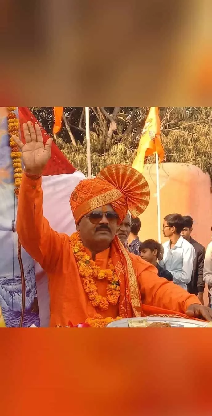 केसरिया साफा और माला पहने हुए हेमराज दीक्षित हाथ उठाकर अभिवादन करते हुए। केसरिया साफा और माला पहने हुए हेमराज दीक्षित हाथ उठाकर अभिवादन करते हुए।