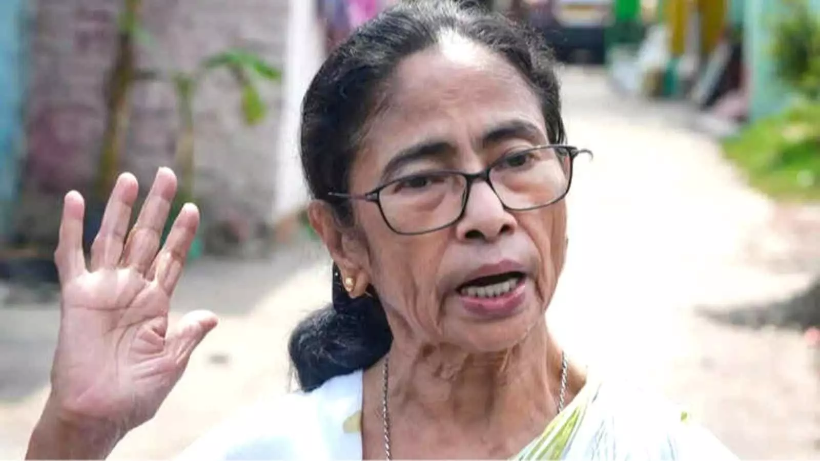 चश्मा पहने और सफेद वस्त्र धारण किए अपना दाहिना हाथ उठाकर बोलतीं नेता ममता बनर्जी। चश्मा पहने और सफेद वस्त्र धारण किए अपना दाहिना हाथ उठाकर बोलतीं नेता ममता बनर्जी।