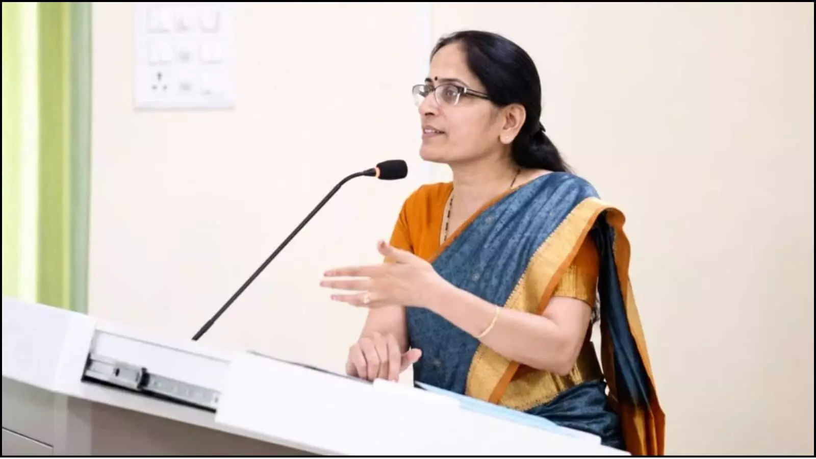 पोडियम पर माइक के सामने बोलती हुईं साड़ी और चश्मा पहने वरिष्ठ अधिवक्ता वी. मोहना नई दिल्ली के एक कानूनी सेमिनार में। पोडियम पर माइक के सामने बोलती हुईं साड़ी और चश्मा पहने वरिष्ठ अधिवक्ता वी. मोहना नई दिल्ली के एक कानूनी सेमिनार में।