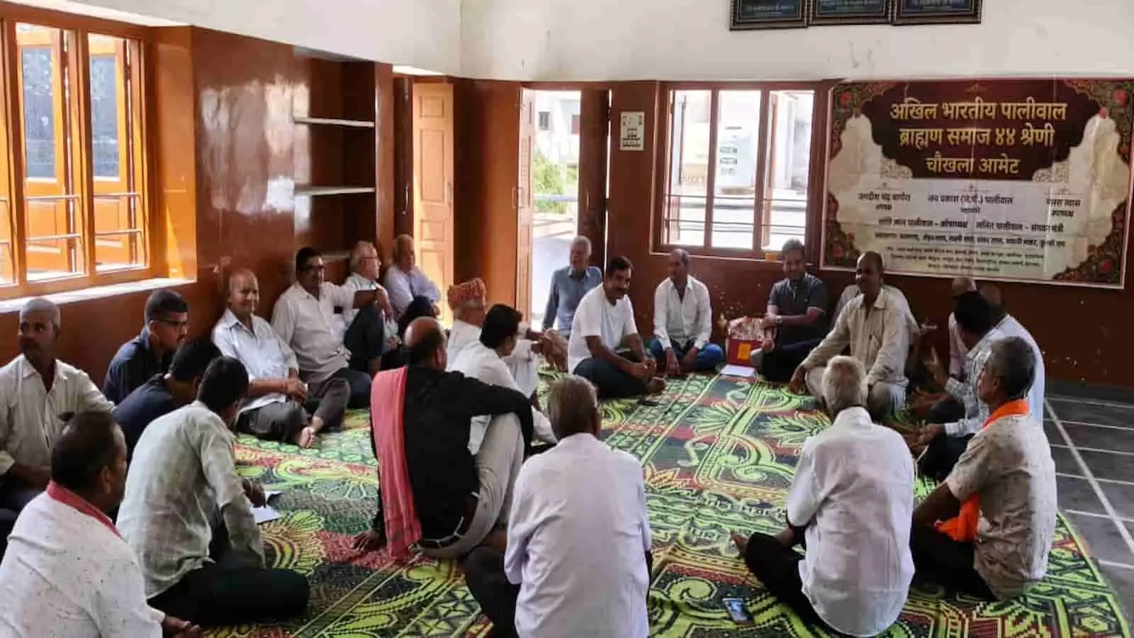 पालीवाल समाज भवन आमेट में दरी पर बैठकर बैठक करते समाज के पदाधिकारी और प्रतिनिधि सदस्य।