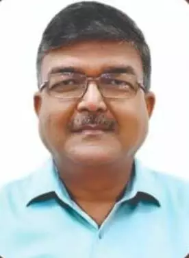 चश्मा और नीली शर्ट पहने अतिरिक्त जिला मजिस्ट्रेट नरेंद्र कुमार वर्मा जयपुर में आरपीएससी परीक्षा समन्वय के संदर्भ में दिख रहे हैं।