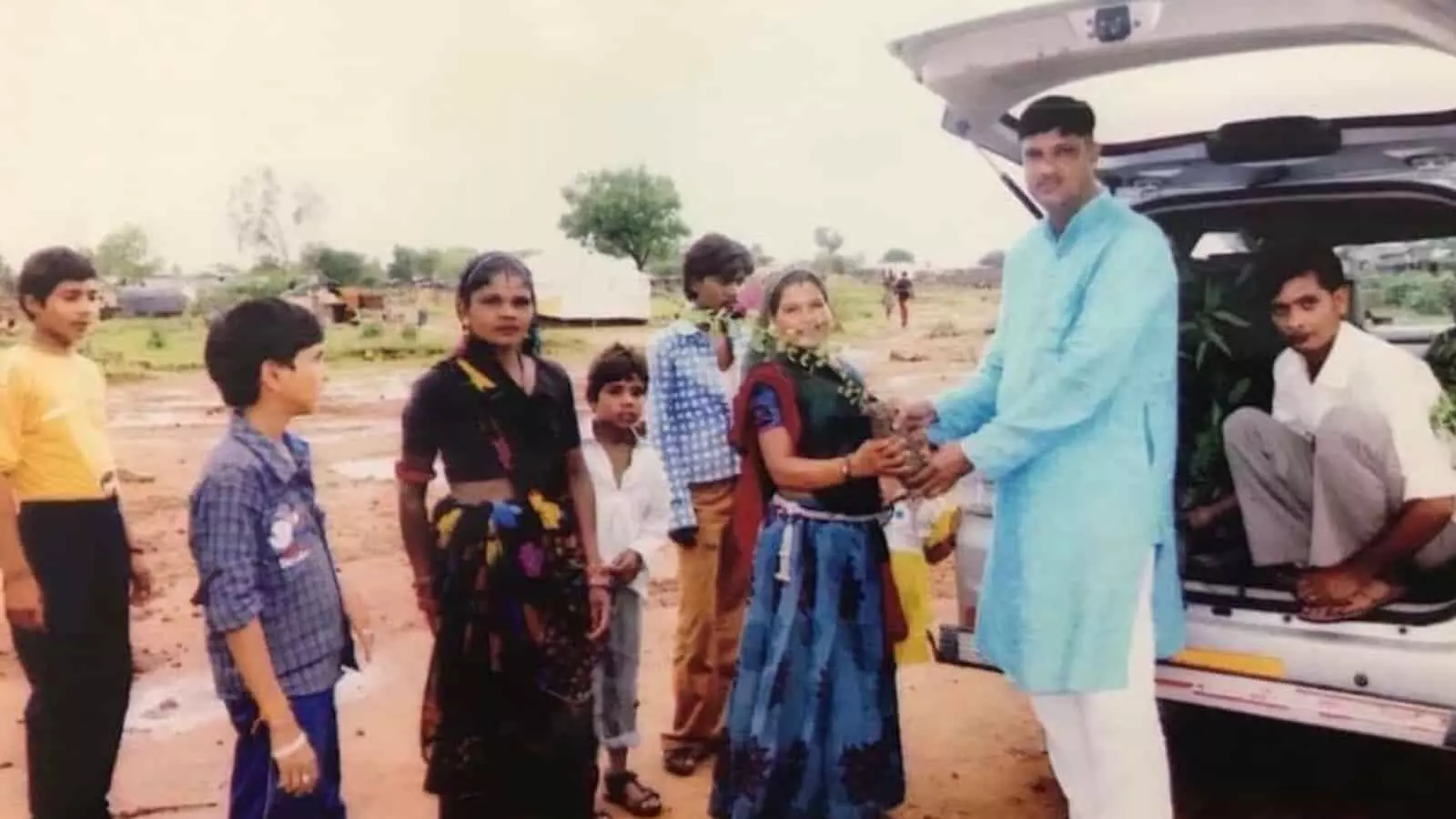 गाड़ी के पास खड़ी महिला को पौधा सौंपते हुए गोविंद अटलपुरी और स्थानीय ग्रामीण। गाड़ी के पास खड़ी महिला को पौधा सौंपते हुए गोविंद अटलपुरी और स्थानीय ग्रामीण।