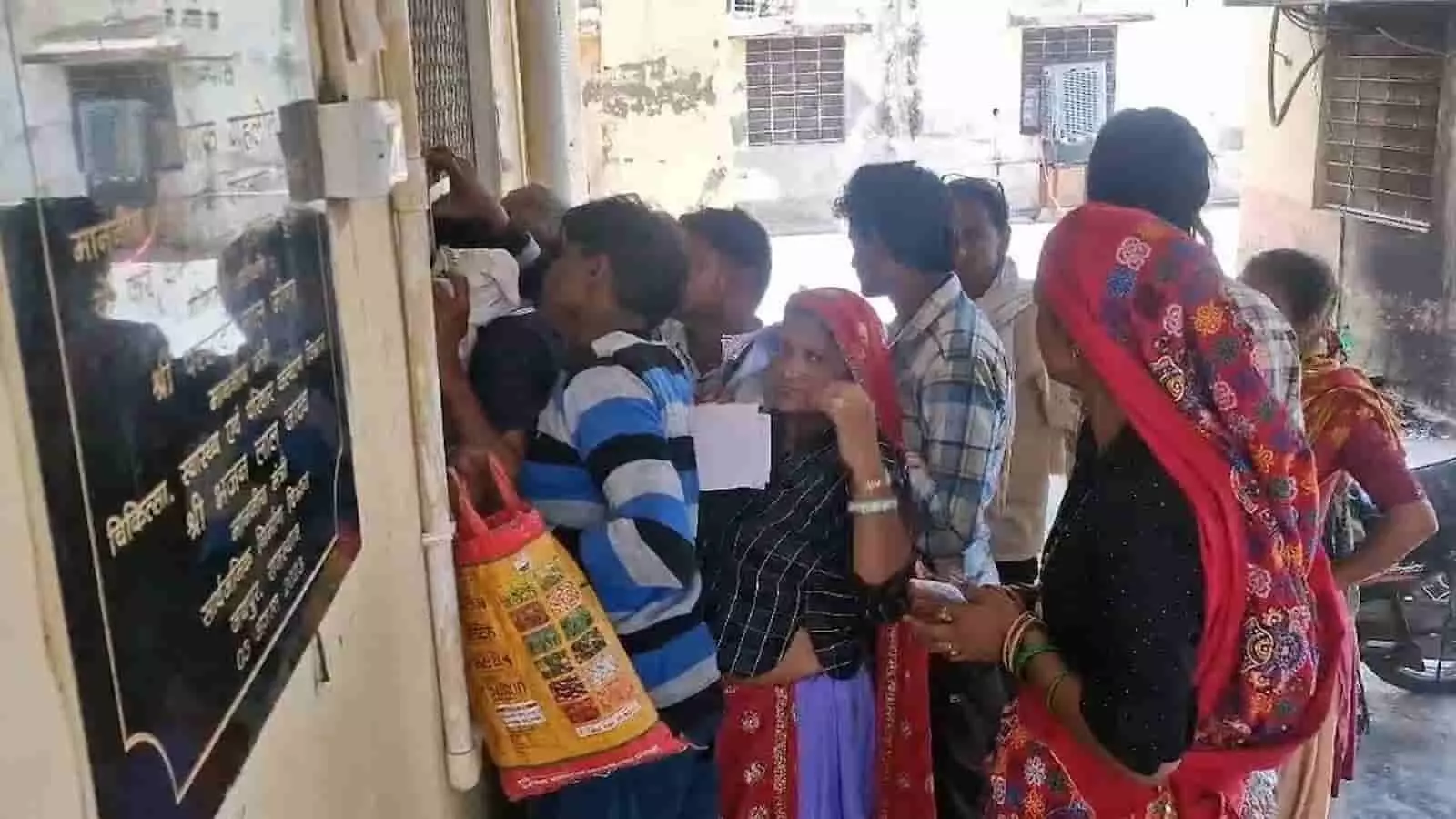 भुसावर सीएचसी में खिड़की पर जांच पर्ची लेकर कतार में खड़े ग्रामीण मरीज और महिलाएं