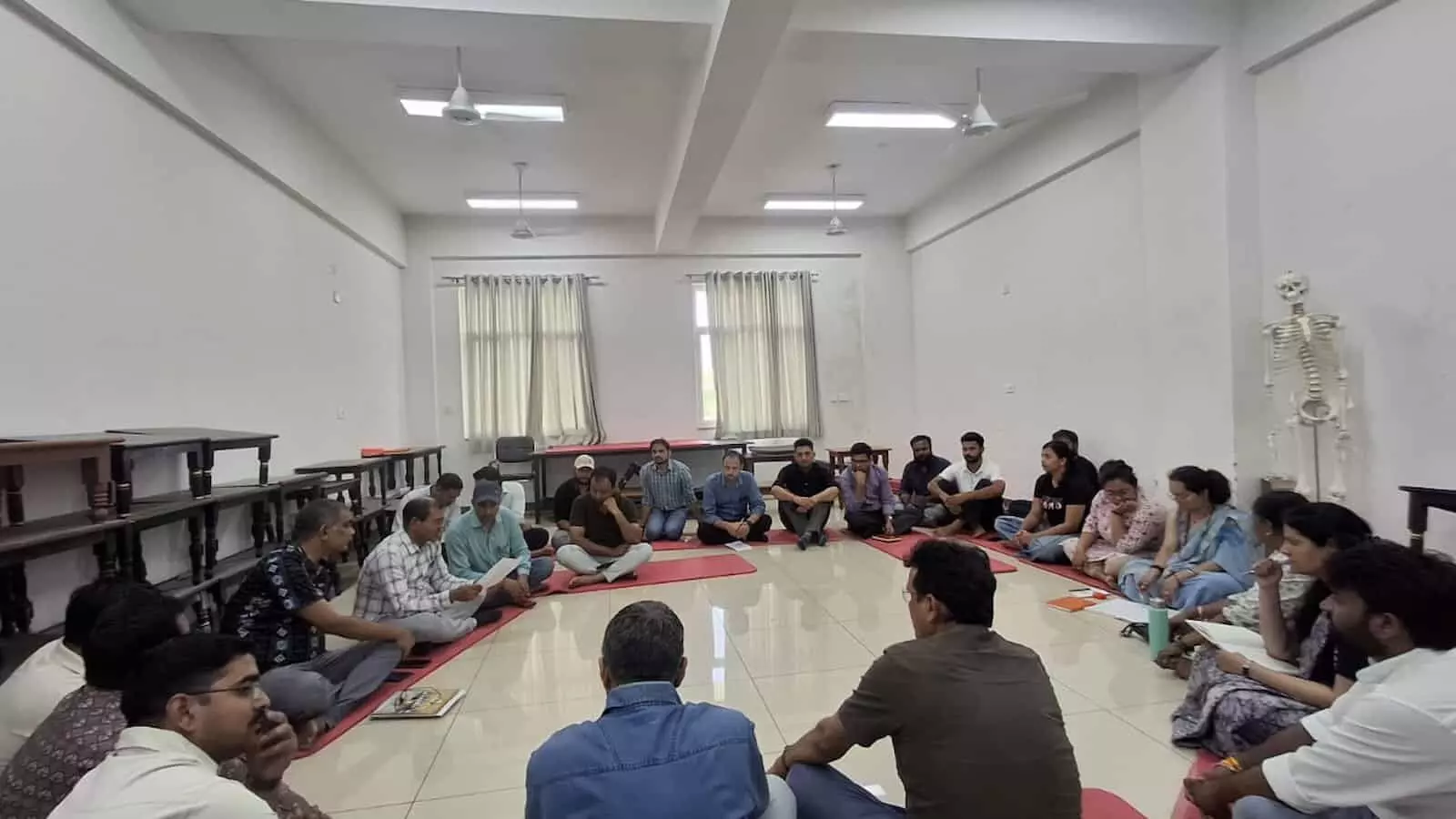 विश्वविद्यालय के सभागार में चटाई पर बैठकर सांगठनिक बैठक करते भारतीय शिक्षण मंडल के सदस्य और शिक्षक। विश्वविद्यालय के सभागार में चटाई पर बैठकर सांगठनिक बैठक करते भारतीय शिक्षण मंडल के सदस्य और शिक्षक।