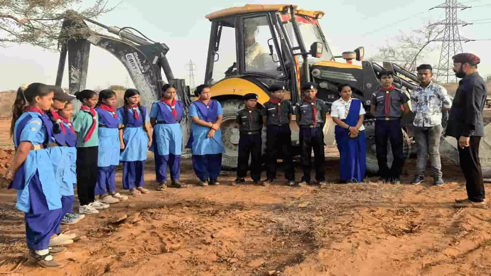 कोटा के आंवली वन क्षेत्र में जेसीबी मशीन के सामने कतार में खड़े स्काउट-गाइड और अधिकारी जल संरक्षण कार्य के संदर्भ में। कोटा के आंवली वन क्षेत्र में जेसीबी मशीन के सामने कतार में खड़े स्काउट-गाइड और अधिकारी जल संरक्षण कार्य के संदर्भ में।