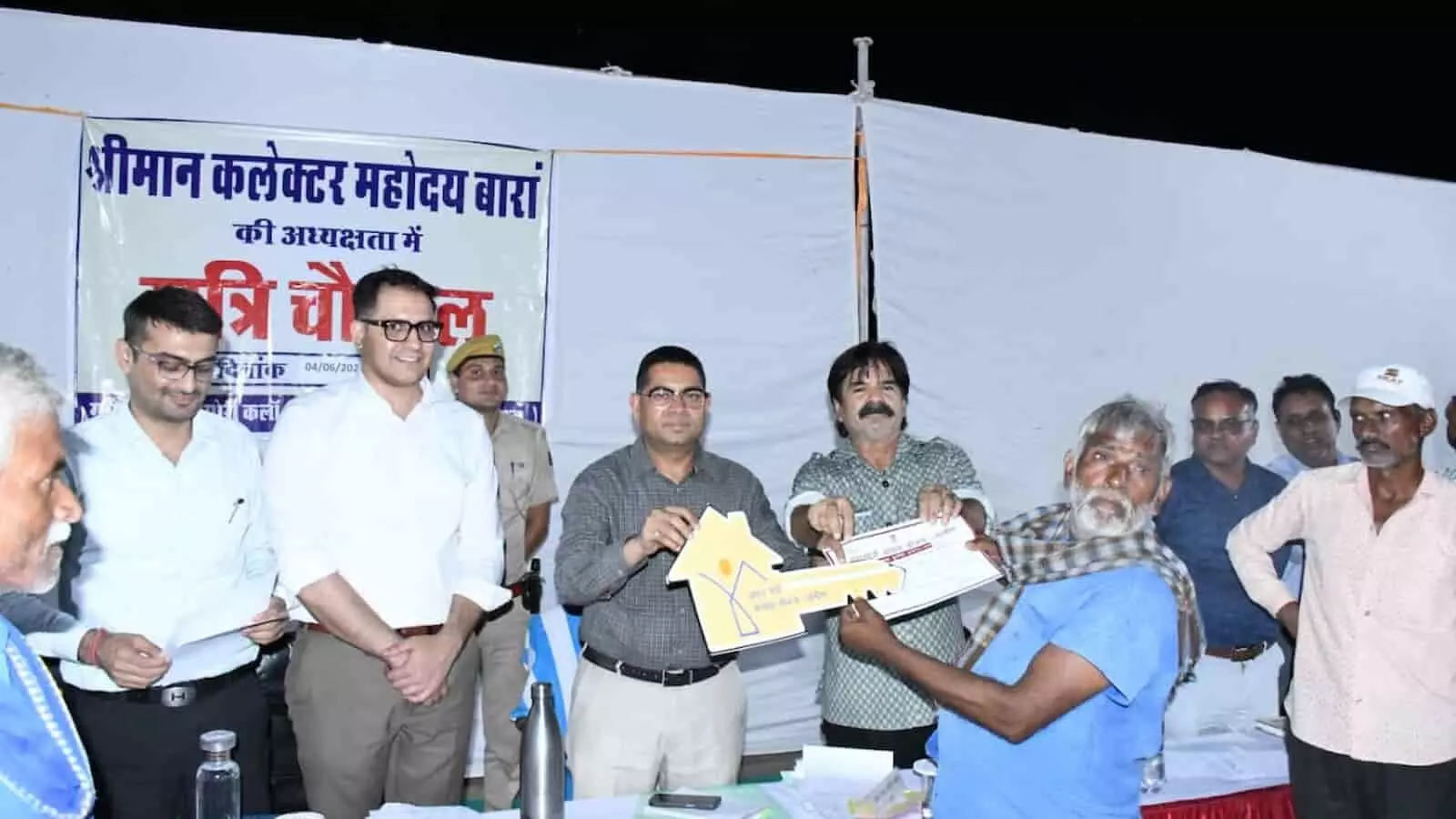 रात्रि चौपाल मंच पर एक ग्रामीण को आवास योजना का स्वीकृति पत्र सौंपते जिला कलेक्टर बालमुकुंद असावा और प्रशासनिक अधिकारी। रात्रि चौपाल मंच पर एक ग्रामीण को आवास योजना का स्वीकृति पत्र सौंपते जिला कलेक्टर बालमुकुंद असावा और प्रशासनिक अधिकारी।