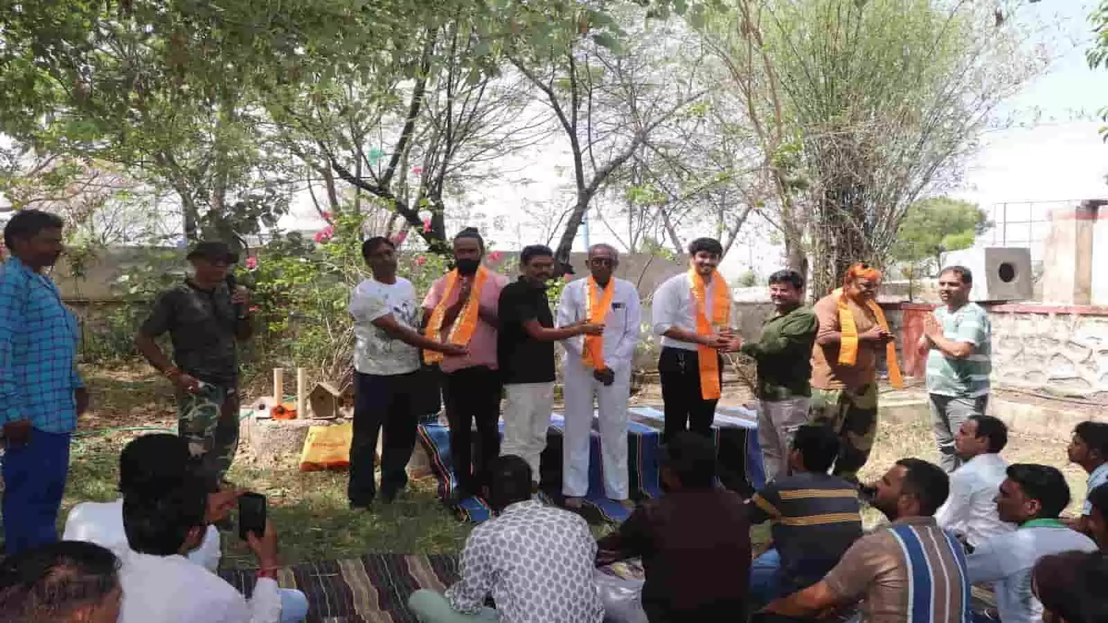 उद्यान में दरी पर बैठे लोगों के सामने मंच पर खड़े होकर वरिष्ठ जनों का सम्मान करते हुए पर्यावरण प्रेमी। उद्यान में दरी पर बैठे लोगों के सामने मंच पर खड़े होकर वरिष्ठ जनों का सम्मान करते हुए पर्यावरण प्रेमी।