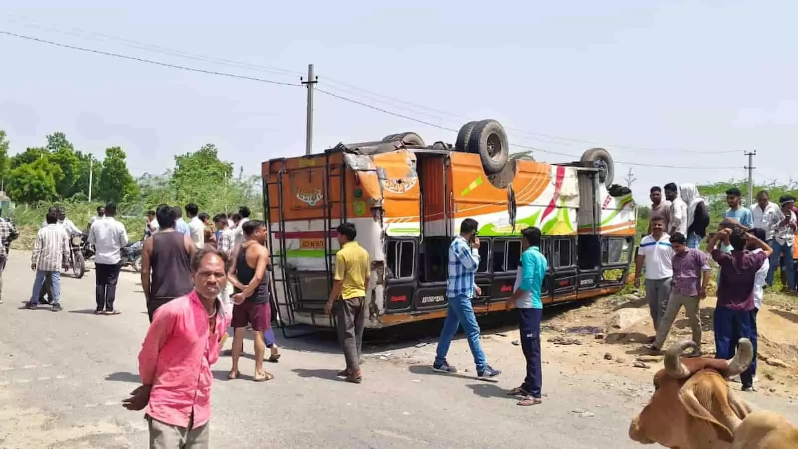 सड़क पर पलटी हुई बस और उसके आसपास खड़े लोग आमेट भीलवाड़ा मार्ग पर दुर्घटना के संदर्भ में।