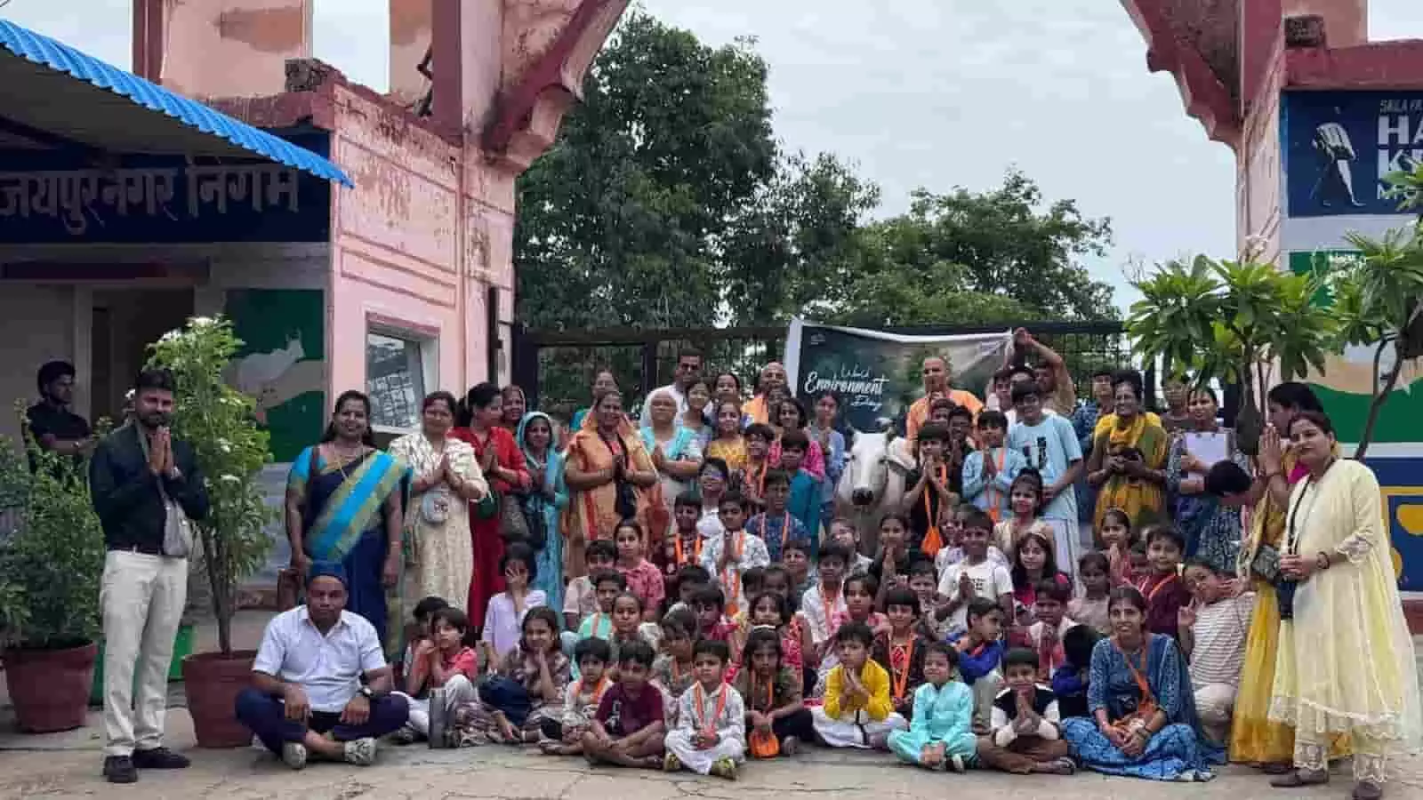 हिंगोनिया गौ पुनर्वास केंद्र के मुख्य द्वार पर विश्व पर्यावरण दिवस कार्यक्रम के दौरान उपस्थित बच्चों और वयस्कों का समूह।
