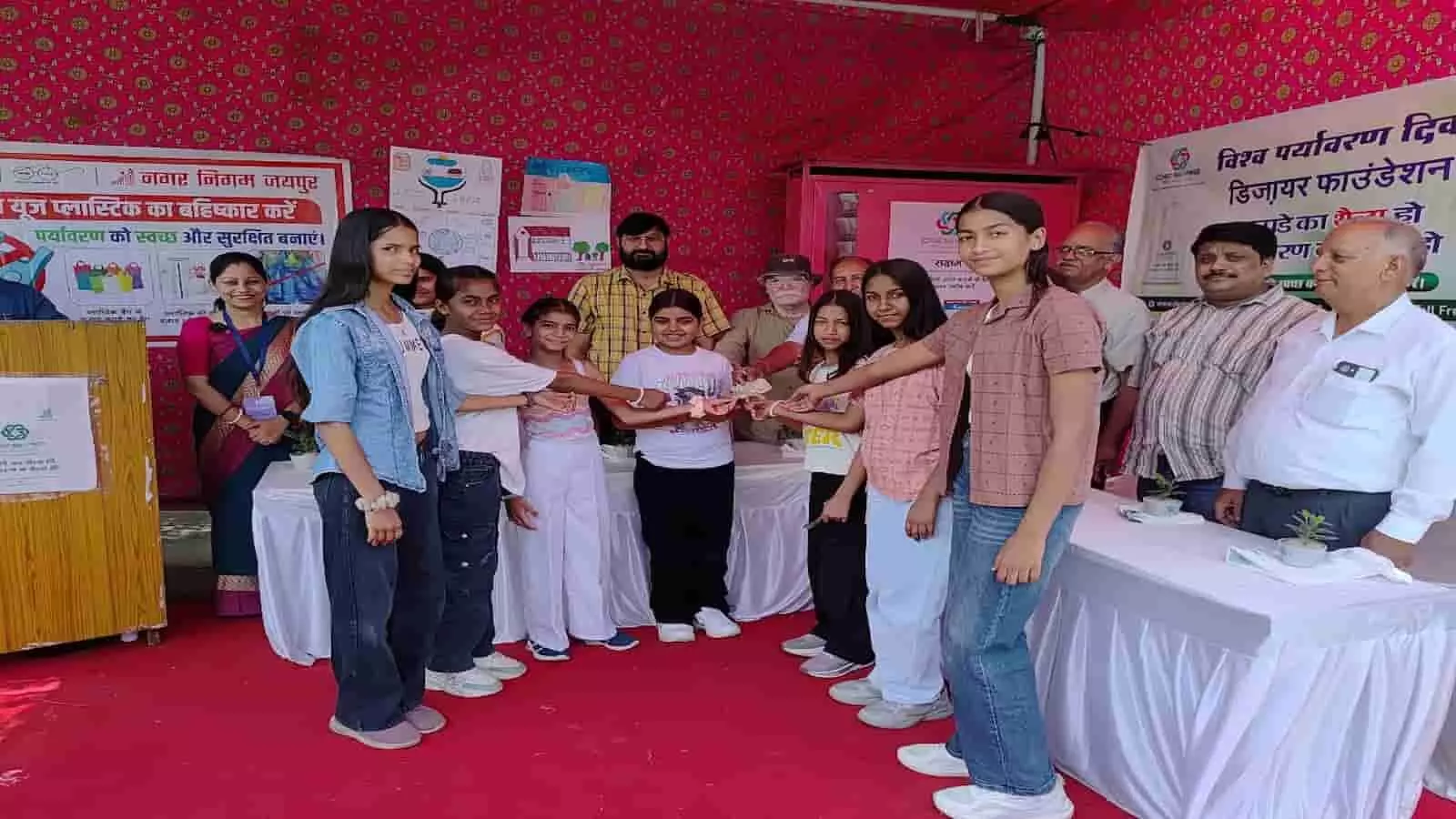 जयपुर नगर निगम के पर्यावरण दिवस कार्यक्रम में उपस्थित बच्चे और अधिकारी मंच पर खड़े हैं।