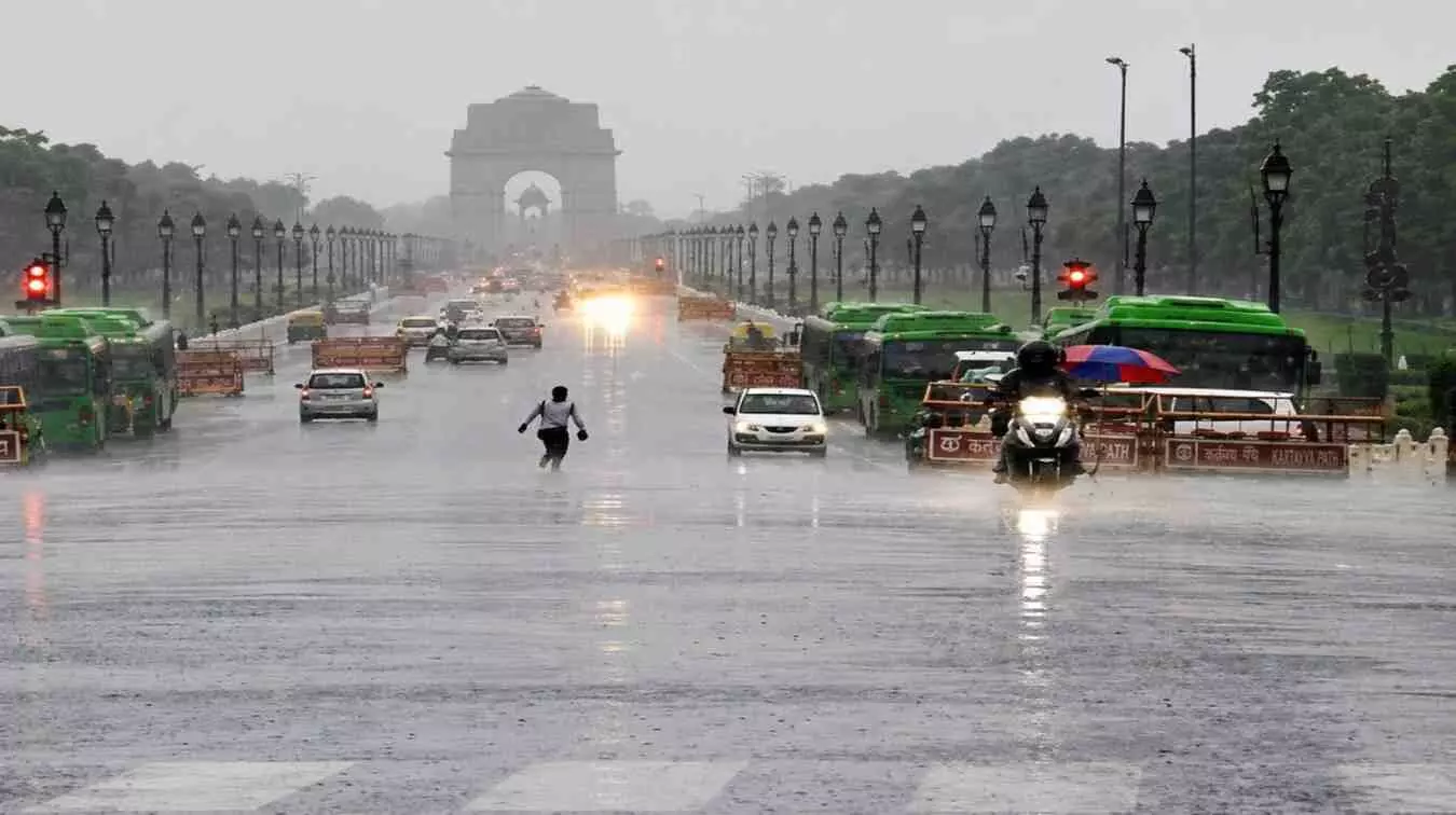 बारिश के मौसम में इंडिया गेट के सामने कर्तव्य पथ पर चलते वाहन और लोग दिखाई दे रहे हैं।
