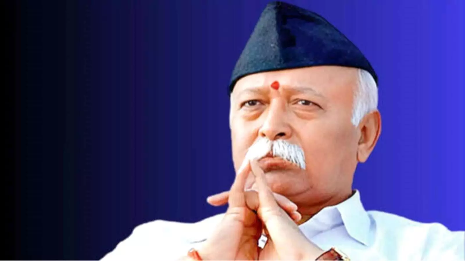 नीली पृष्ठभूमि के सामने काली टोपी पहने राष्ट्रीय स्वयंसेवक संघ के प्रमुख मोहन भागवत विचारमग्न मुद्रा में दिख रहे हैं।