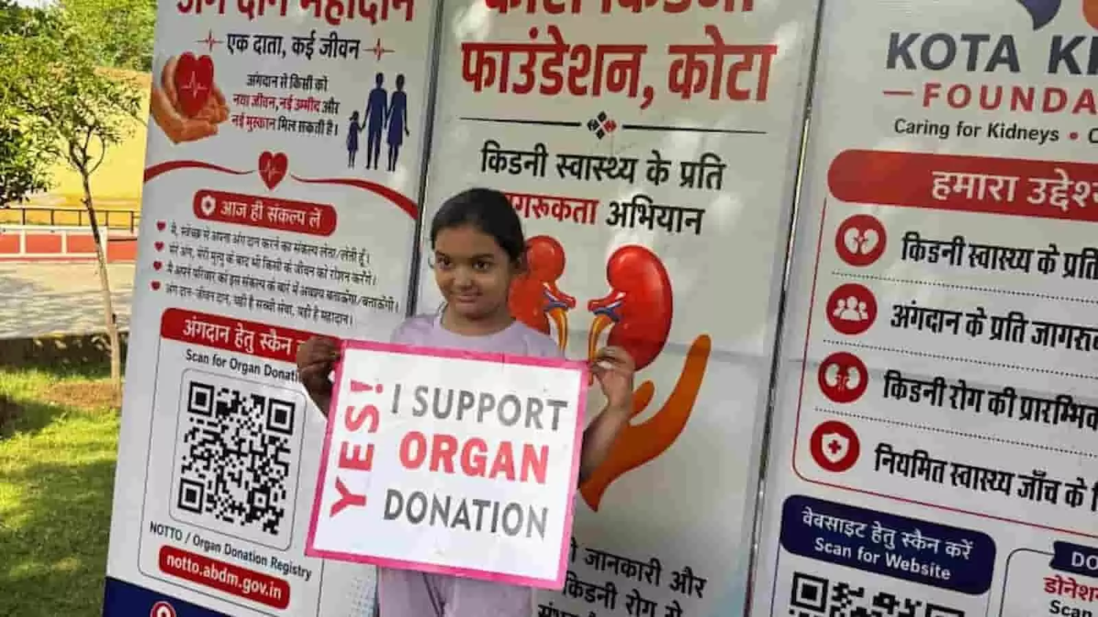 कोटा किडनी फाउंडेशन के जागरूकता बैनर के सामने अंगदान का पोस्टर पकड़े हुए खड़ी एक बालिका। कोटा किडनी फाउंडेशन के जागरूकता बैनर के सामने अंगदान का पोस्टर पकड़े हुए खड़ी एक बालिका।