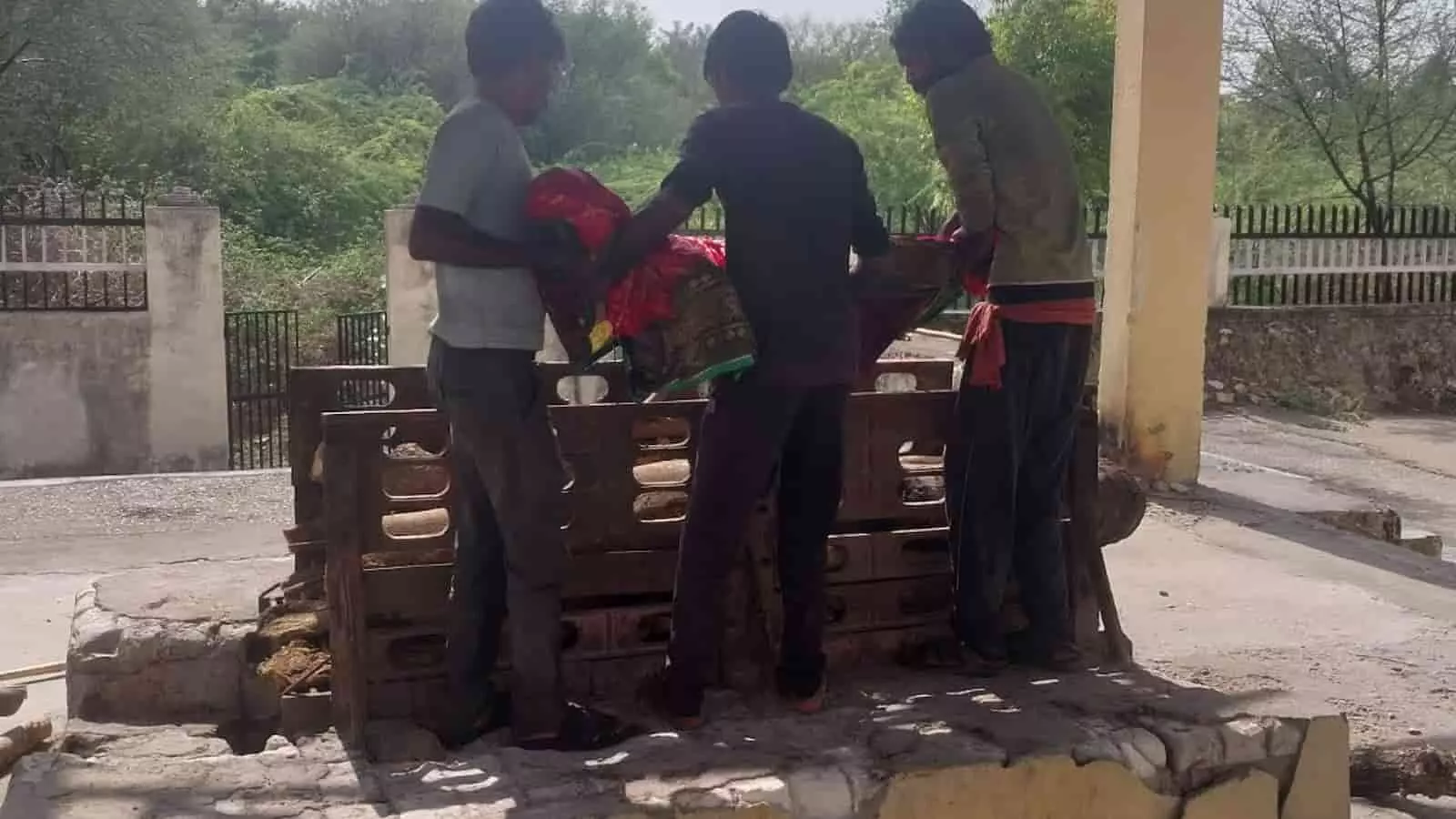 नगरपालिका क्षेत्र के श्मशान घाट में सफाईकर्मी बेसहारा वृद्ध महिला के शव का सम्मानजनक अंतिम संस्कार कर रहे हैं।