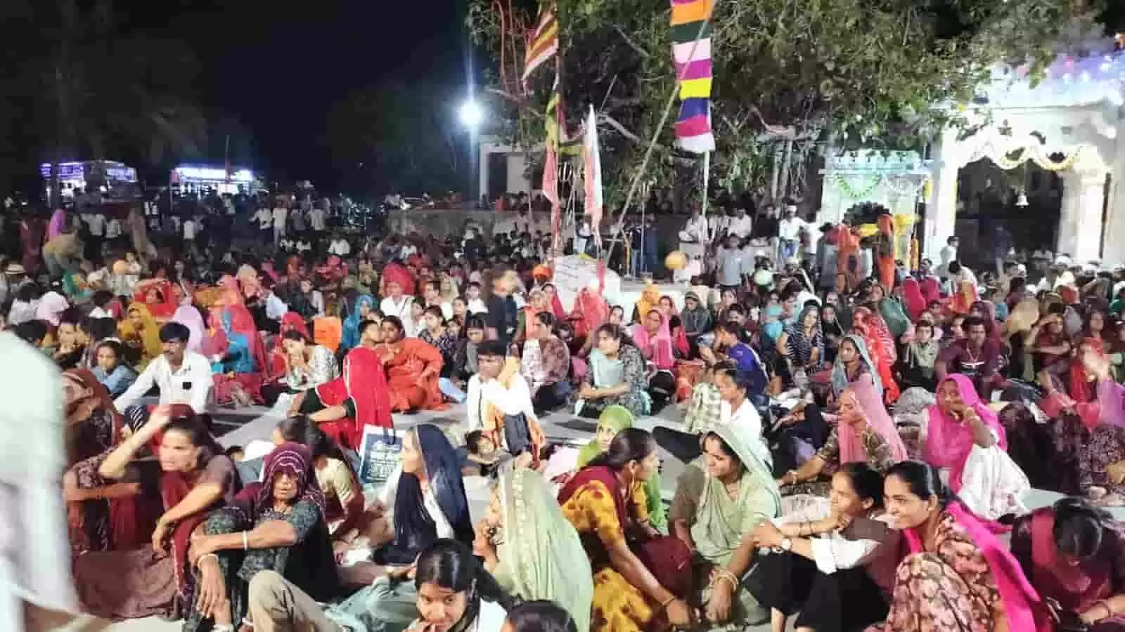 बिकावास माताजी मंदिर परिसर में आयोजित भजन संध्या के दौरान जमीन पर बैठे हजारों श्रद्धालु और भक्तगण।