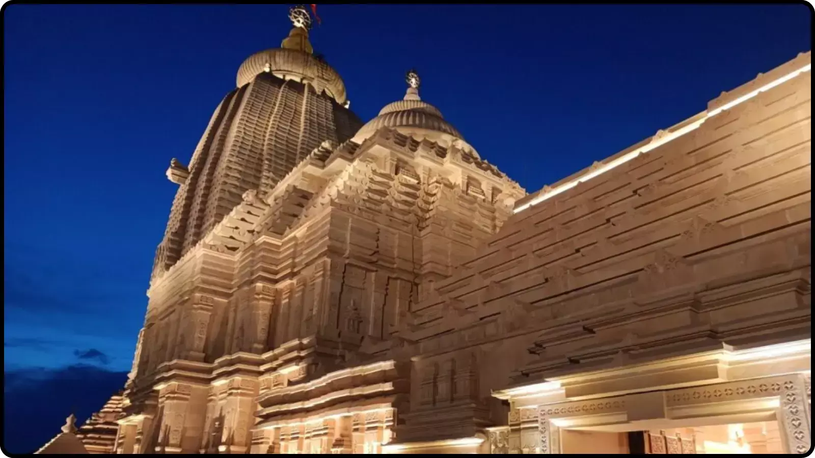 रात के समय नीले आसमान के नीचे कृत्रिम रोशनी से चमकता हुआ दीघा का नवनिर्मित जगन्नाथ मंदिर।