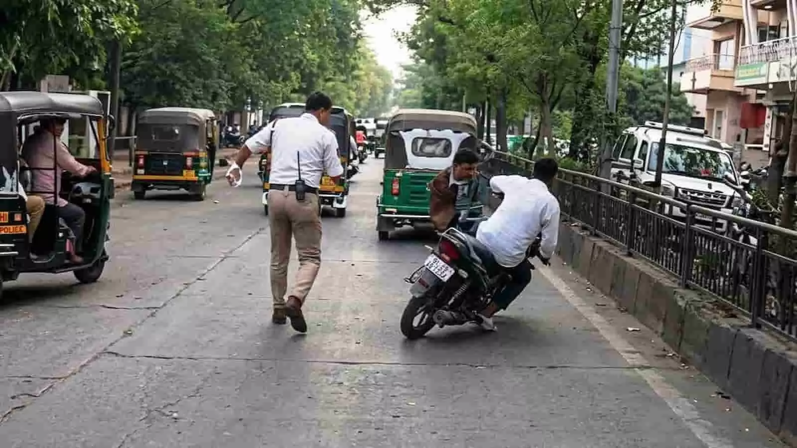 लातूर के मिनी मार्केट में बीच सड़क पर एक ट्रैफिक पुलिसकर्मी और असंतुलित होकर गिरते मोटरसाइकिल सवार का दृश्य। लातूर के मिनी मार्केट में बीच सड़क पर एक ट्रैफिक पुलिसकर्मी और असंतुलित होकर गिरते मोटरसाइकिल सवार का दृश्य।