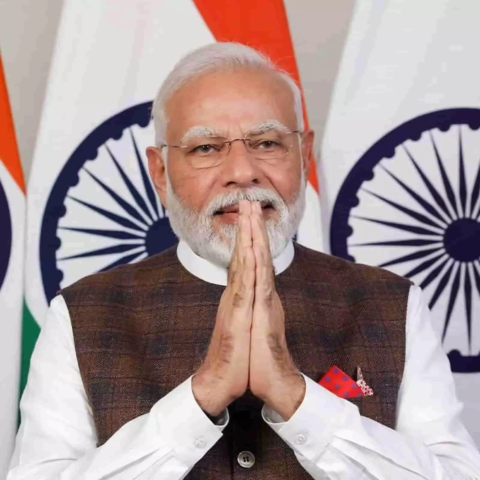 सफेद कुर्ता और भूरे रंग की जैकेट पहने प्रधानमंत्री नरेंद्र मोदी राष्ट्रीय ध्वज के सामने हाथ जोड़कर खड़े हैं। सफेद कुर्ता और भूरे रंग की जैकेट पहने प्रधानमंत्री नरेंद्र मोदी राष्ट्रीय ध्वज के सामने हाथ जोड़कर खड़े हैं।