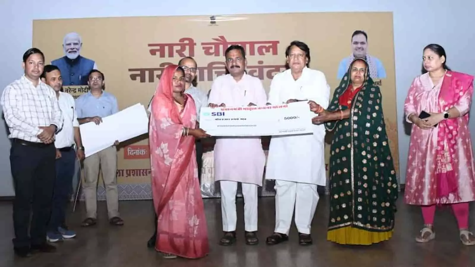 तस्वीर में अतिथि और अधिकारी मंच पर एक महिला को प्रधानमंत्री मातृत्व वंदना योजना का चेक प्रदान करते हुए दिख रहे हैं। तस्वीर में अतिथि और अधिकारी मंच पर एक महिला को प्रधानमंत्री मातृत्व वंदना योजना का चेक प्रदान करते हुए दिख रहे हैं।