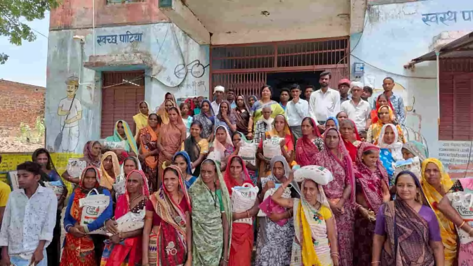 तस्वीर में पाटीया ग्राम पंचायत भवन के सामने ग्रामीण महिलाएं और पुरुष हाथों में बीज के पैकेट लिए समूह में खड़े हैं। तस्वीर में पाटीया ग्राम पंचायत भवन के सामने ग्रामीण महिलाएं और पुरुष हाथों में बीज के पैकेट लिए समूह में खड़े हैं।