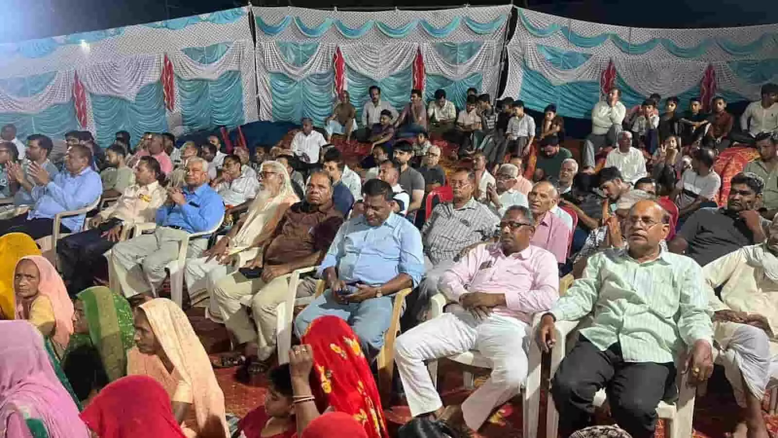 तस्वीर में एक बड़े पंडाल के नीचे कुर्सियों पर बैठकर कथा सुनते हुए बहुत से महिला और पुरुष श्रद्धालु। तस्वीर में एक बड़े पंडाल के नीचे कुर्सियों पर बैठकर कथा सुनते हुए बहुत से महिला और पुरुष श्रद्धालु।