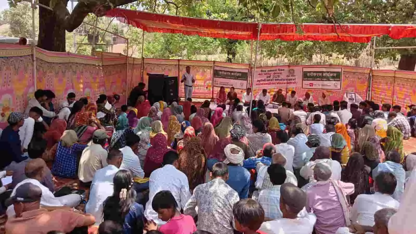 तस्वीर में एक शामियाने के नीचे जमीन पर बैठकर पर्यावरण जागरूकता कार्यक्रम में भाग लेते हुए बहुत से ग्रामीण। तस्वीर में एक शामियाने के नीचे जमीन पर बैठकर पर्यावरण जागरूकता कार्यक्रम में भाग लेते हुए बहुत से ग्रामीण।