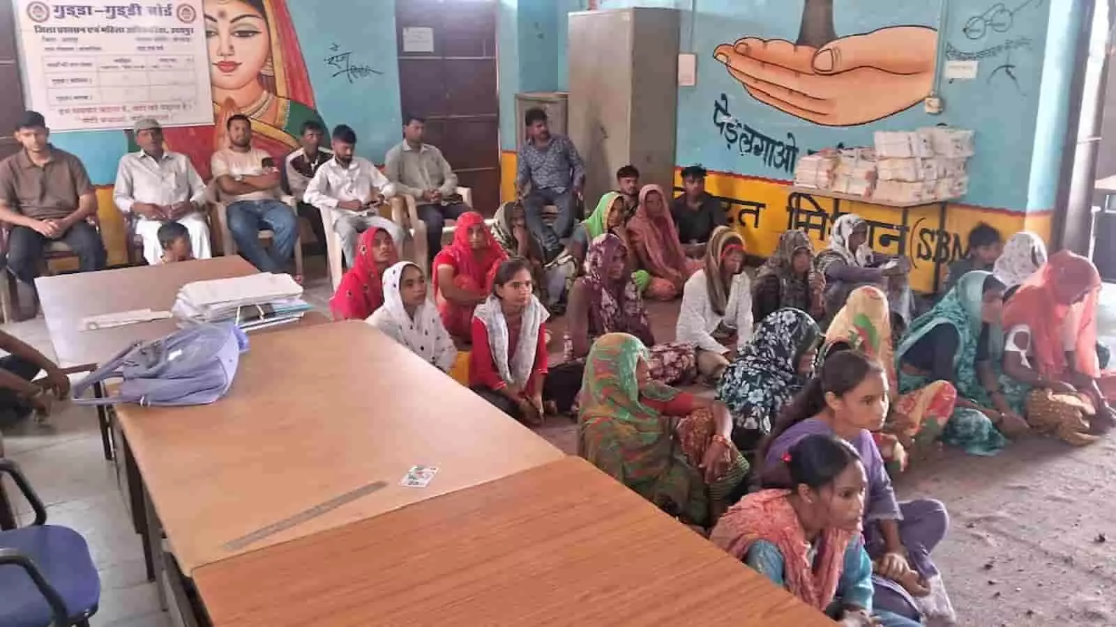 तस्वीर में बहुत सी ग्रामीण महिलाएं एक कमरे में जमीन पर बैठकर कृषि विभाग के कार्यक्रम में भाग लेती हुई। तस्वीर में बहुत सी ग्रामीण महिलाएं एक कमरे में जमीन पर बैठकर कृषि विभाग के कार्यक्रम में भाग लेती हुई।