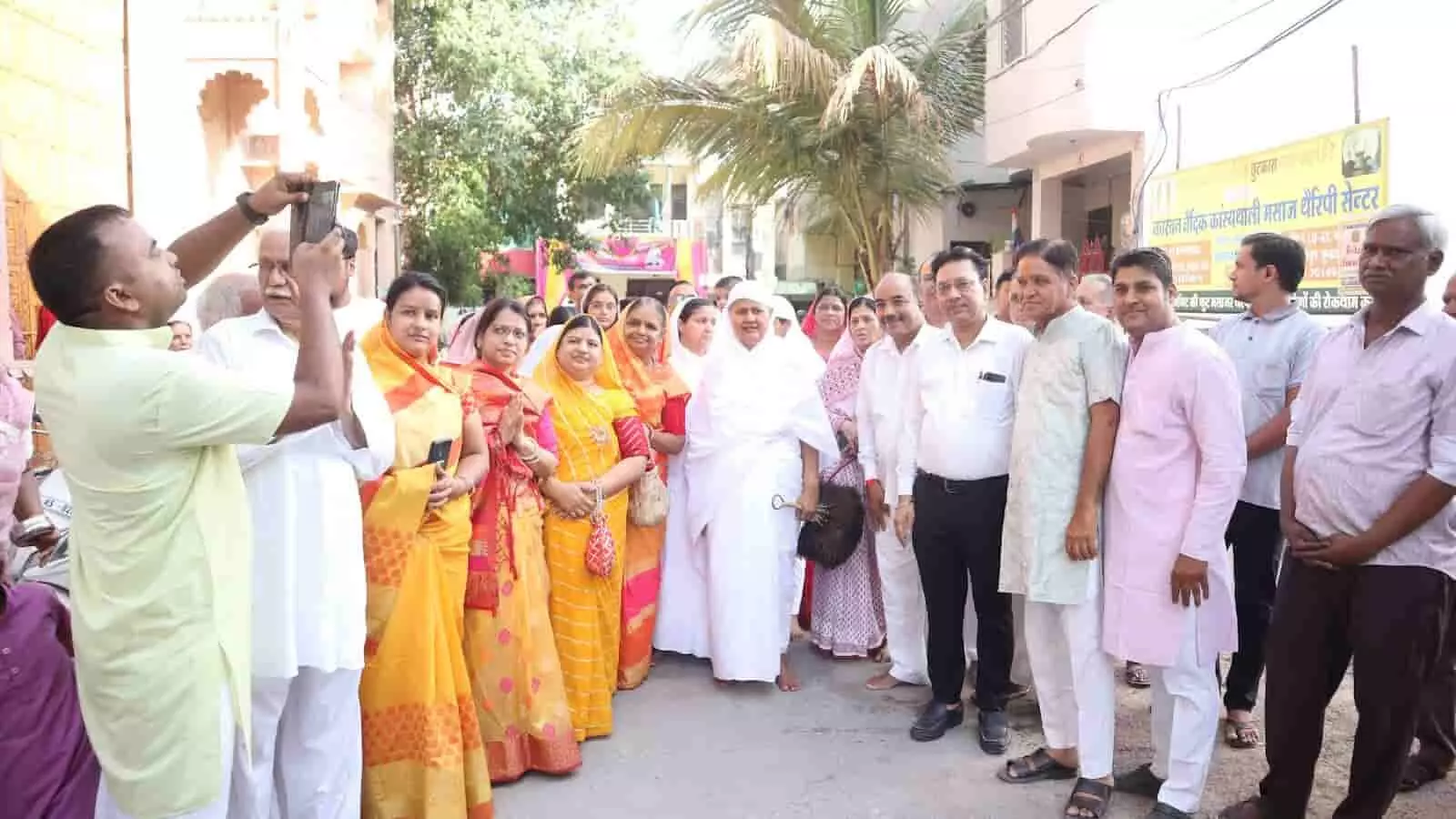 तस्वीर में कुछ लोग सड़क पर सफेद वस्त्र पहने एक जैन साध्वी के समीप खड़े हुए। तस्वीर में कुछ लोग सड़क पर सफेद वस्त्र पहने एक जैन साध्वी के समीप खड़े हुए।