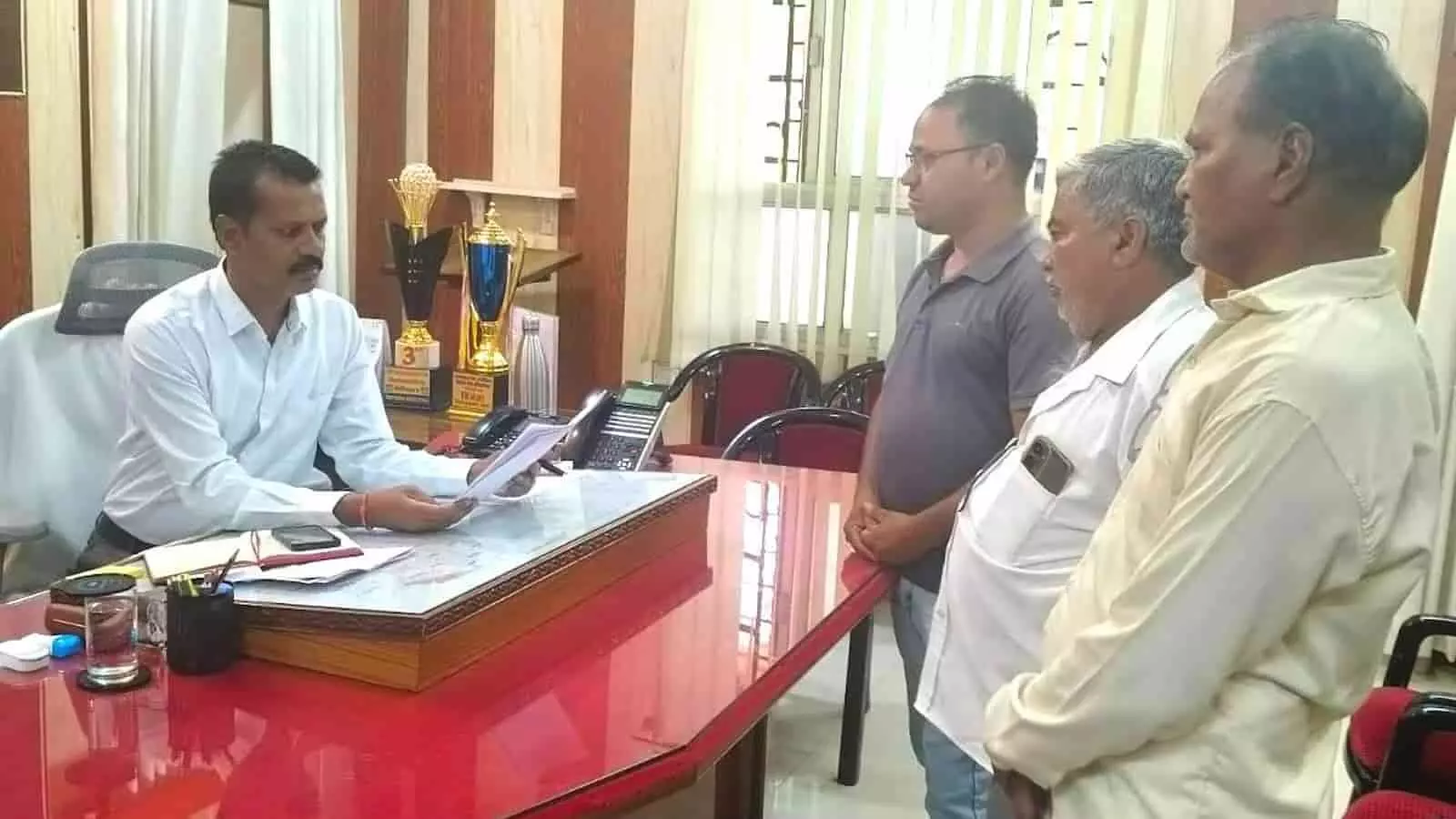 तस्वीर में कार्यालय कक्ष के भीतर मेज के सामने खड़े हुए लोग भीलवाड़ा में राशन डीलरों द्वारा ज्ञापन सौंपने के संदर्भ में दिख रहे हैं। तस्वीर में कार्यालय कक्ष के भीतर मेज के सामने खड़े हुए लोग भीलवाड़ा में राशन डीलरों द्वारा ज्ञापन सौंपने के संदर्भ में दिख रहे हैं।
