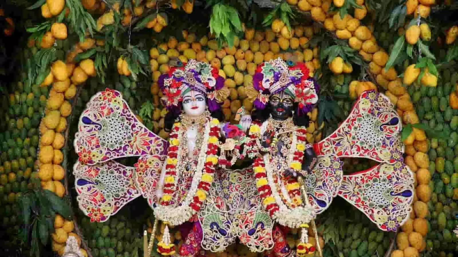 तस्वीर में पीले और हरे आमों के अनूठे तथा भव्य श्रृंगार के बीच मुस्कुराते हुए भगवान श्री कृष्ण और बलराम जी की युगल मूर्तियां आध्यात्मिक वैभव के संदर्भ में दिख रही हैं।