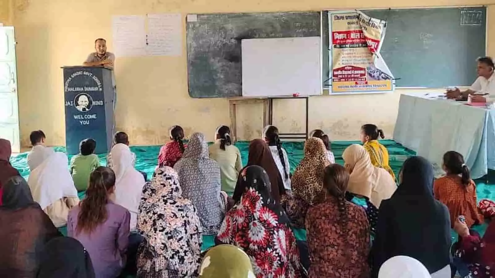 तस्वीर में एक सरकारी विद्यालय के कक्षा कक्ष के भीतर ट्रेनर पोडियम से छात्राओं को अंग्रेजी संवाद कौशल का प्रशिक्षण देते हुए दिख रहे हैं। तस्वीर में एक सरकारी विद्यालय के कक्षा कक्ष के भीतर ट्रेनर पोडियम से छात्राओं को अंग्रेजी संवाद कौशल का प्रशिक्षण देते हुए दिख रहे हैं।