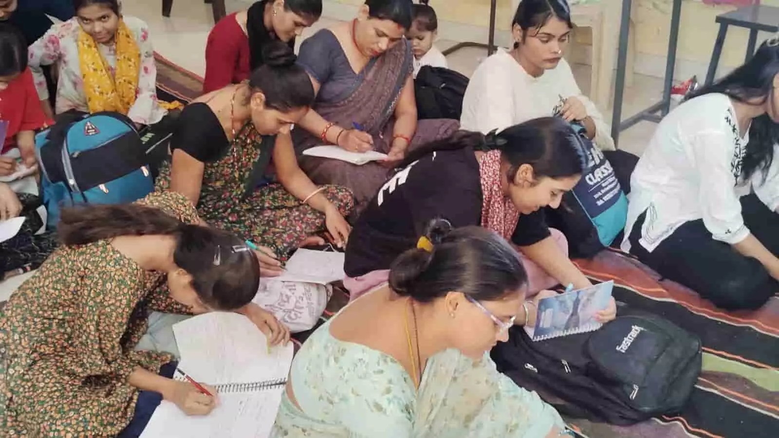 तस्वीर में महिलाएं कोटा के कौशल विकास प्रशिक्षण शिविर में बैठकर नोट्स बना रही हैं। तस्वीर में महिलाएं कोटा के कौशल विकास प्रशिक्षण शिविर में बैठकर नोट्स बना रही हैं।