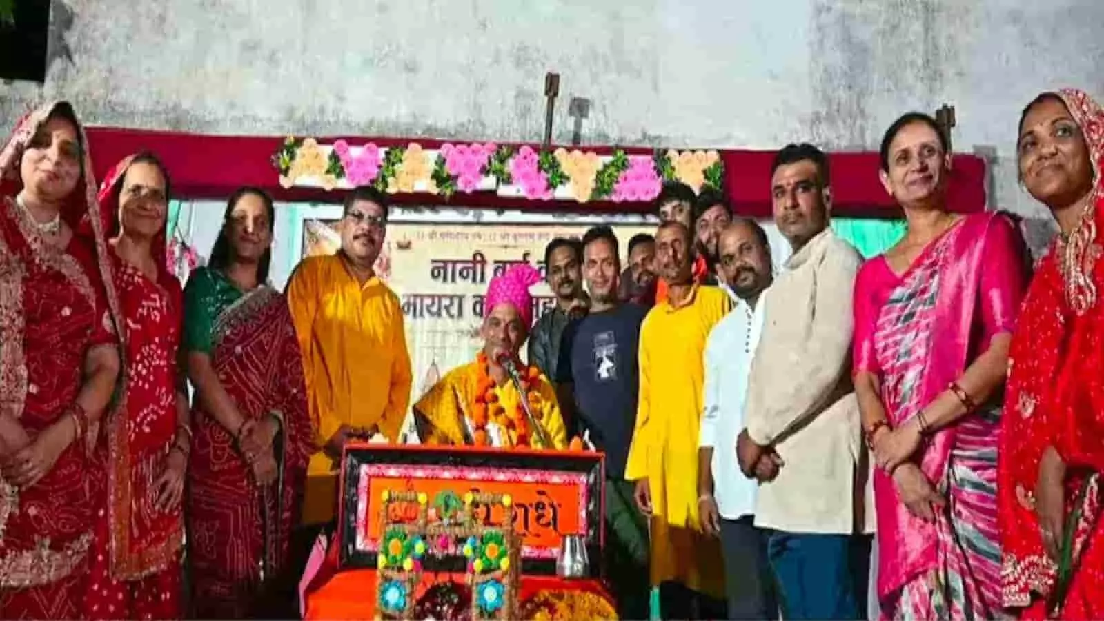तस्वीर में धार्मिक कथा के समापन पर पारंपरिक वेशभूषा पहने महिला और पुरुष श्रद्धालु मंच पर एक साथ खड़े होकर समूह चित्र खिंचवाते हुए दिख रहे हैं। तस्वीर में धार्मिक कथा के समापन पर पारंपरिक वेशभूषा पहने महिला और पुरुष श्रद्धालु मंच पर एक साथ खड़े होकर समूह चित्र खिंचवाते हुए दिख रहे हैं।