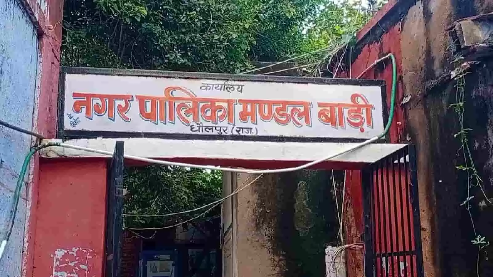 तस्वीर में धौलपुर स्थित कार्यालय नगर पालिका मण्डल बाड़ी का मुख्य प्रवेश द्वार और उस पर लगा नामपट्ट दिख रहा है। तस्वीर में धौलपुर स्थित कार्यालय नगर पालिका मण्डल बाड़ी का मुख्य प्रवेश द्वार और उस पर लगा नामपट्ट दिख रहा है।