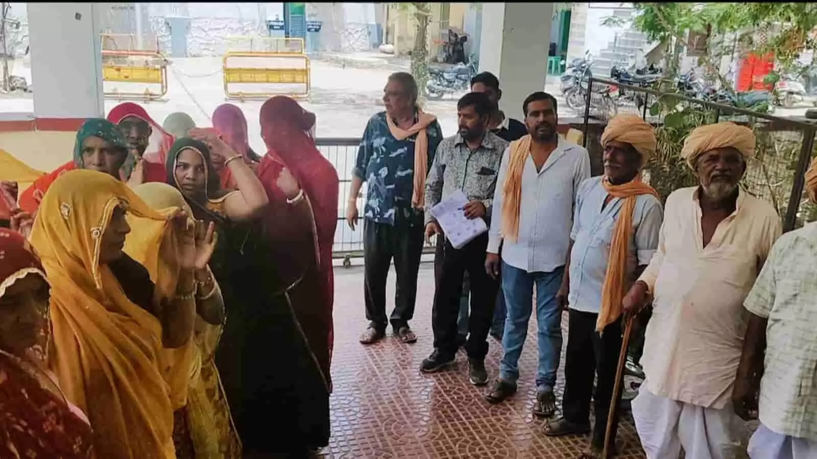 तस्वीर में कई ग्रामीण पुरुष और महिलाएं अपनी मांगों को लेकर उपखंड कार्यालय परिसर के बाहर खड़े होकर बातचीत कर रहे हैं। तस्वीर में कई ग्रामीण पुरुष और महिलाएं अपनी मांगों को लेकर उपखंड कार्यालय परिसर के बाहर खड़े होकर बातचीत कर रहे हैं।