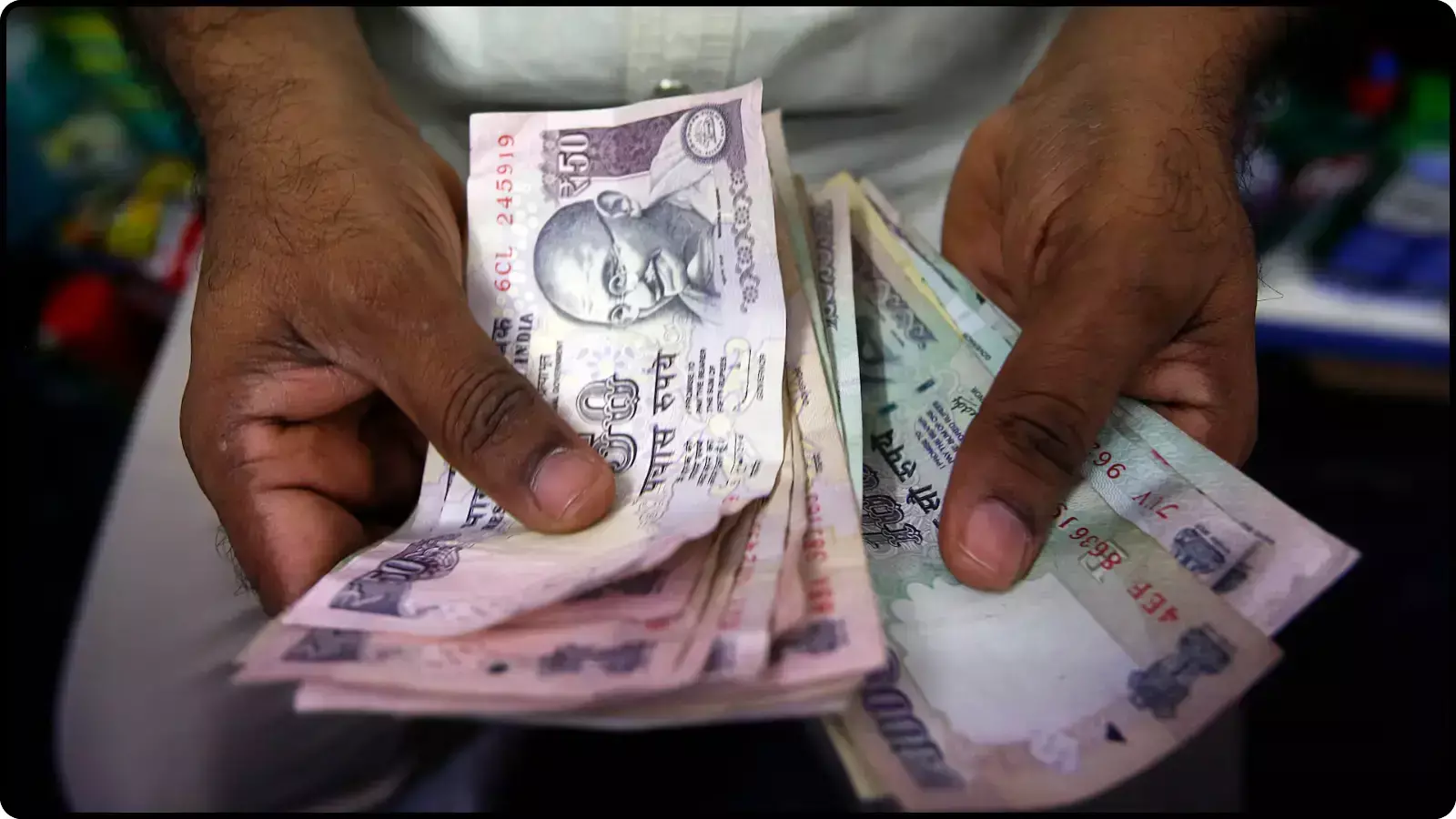 दोनों हाथों में पकड़े हुए भारतीय रुपये के नोटों की गड्डी कूटनीतिक और वित्तीय बाजार के संदर्भ में। दोनों हाथों में पकड़े हुए भारतीय रुपये के नोटों की गड्डी कूटनीतिक और वित्तीय बाजार के संदर्भ में।