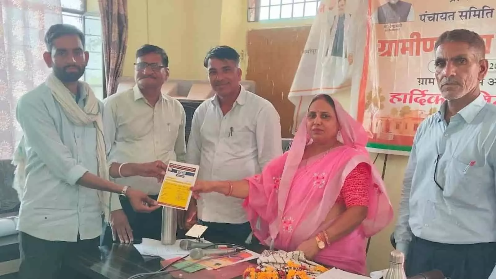 जॉब कार्ड सौंपते पंचायत समिति के प्रतिनिधि और लाभार्थी विजेंद्र बैरवा बिनजारी में।
