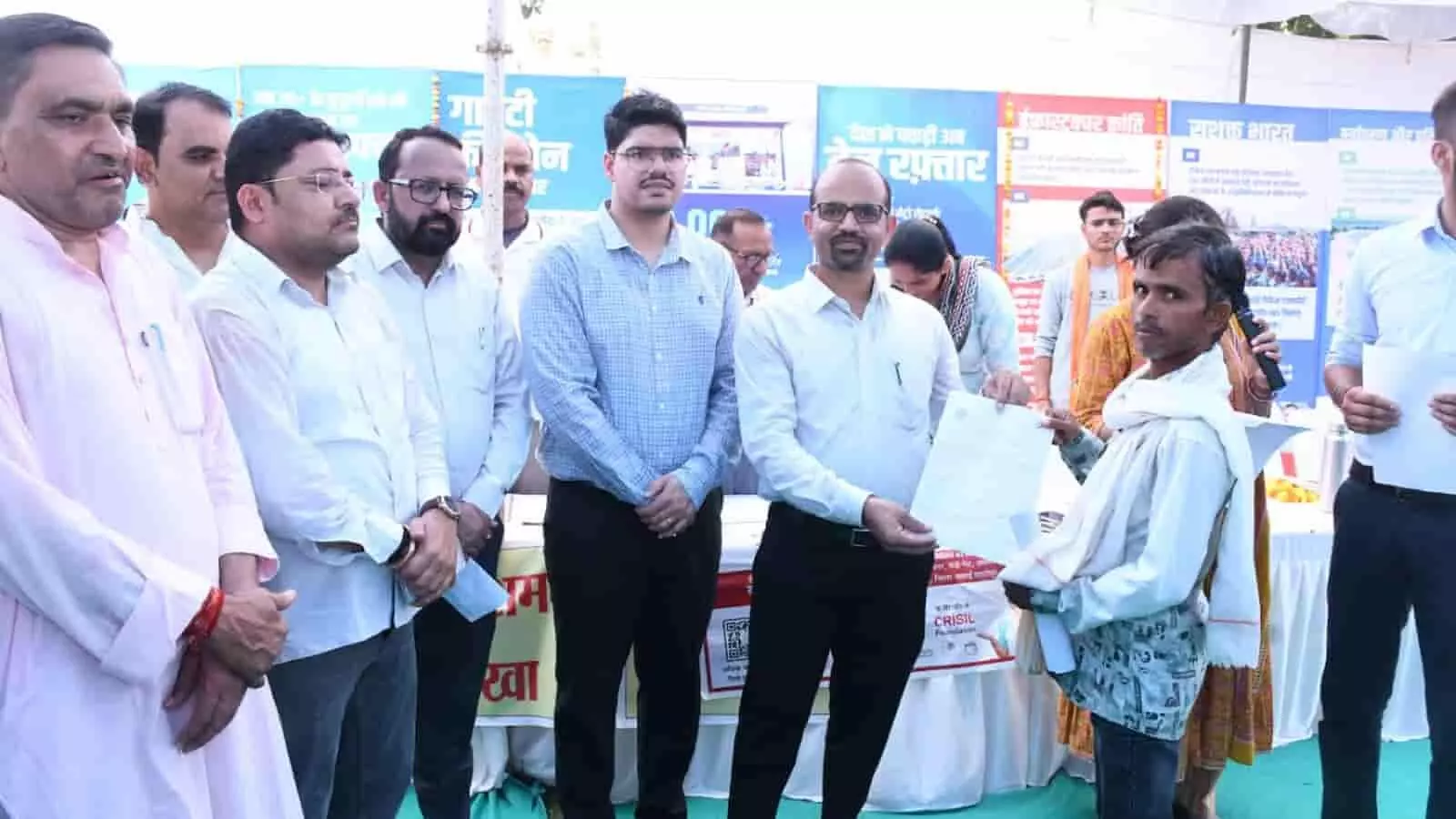 तस्वीर में जिला कलक्टर काना राम सवाई माधोपुर शिविर में लाभार्थी को पट्टा सौंप रहे हैं।