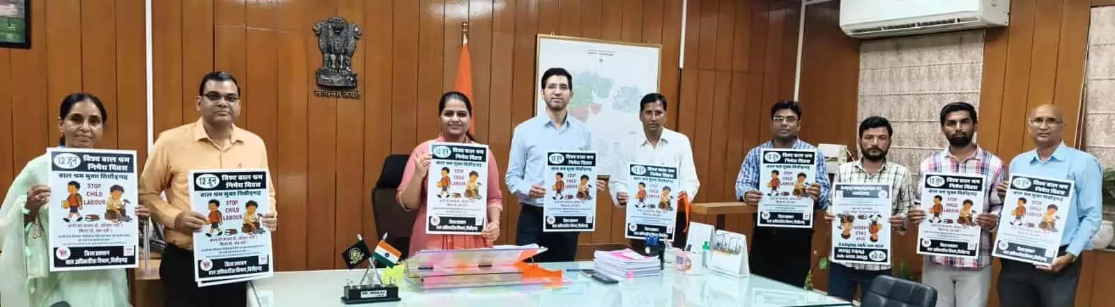चित्तौड़गढ़ जिला कलेक्ट्रेट में बालश्रम निषेध अभियान के पोस्टर के साथ अधिकारी और कर्मचारी।