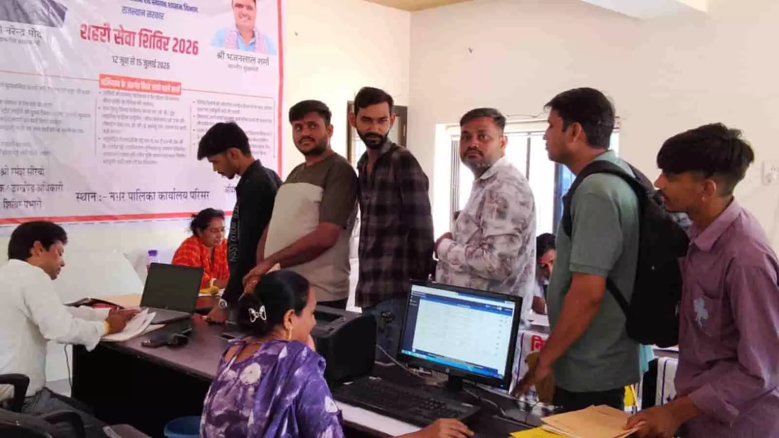 फतेहनगर नगरपालिका परिसर के काउंटर पर कंप्यूटर के सामने अधिकारी और आवेदन देते नागरिक। फतेहनगर नगरपालिका परिसर के काउंटर पर कंप्यूटर के सामने अधिकारी और आवेदन देते नागरिक।