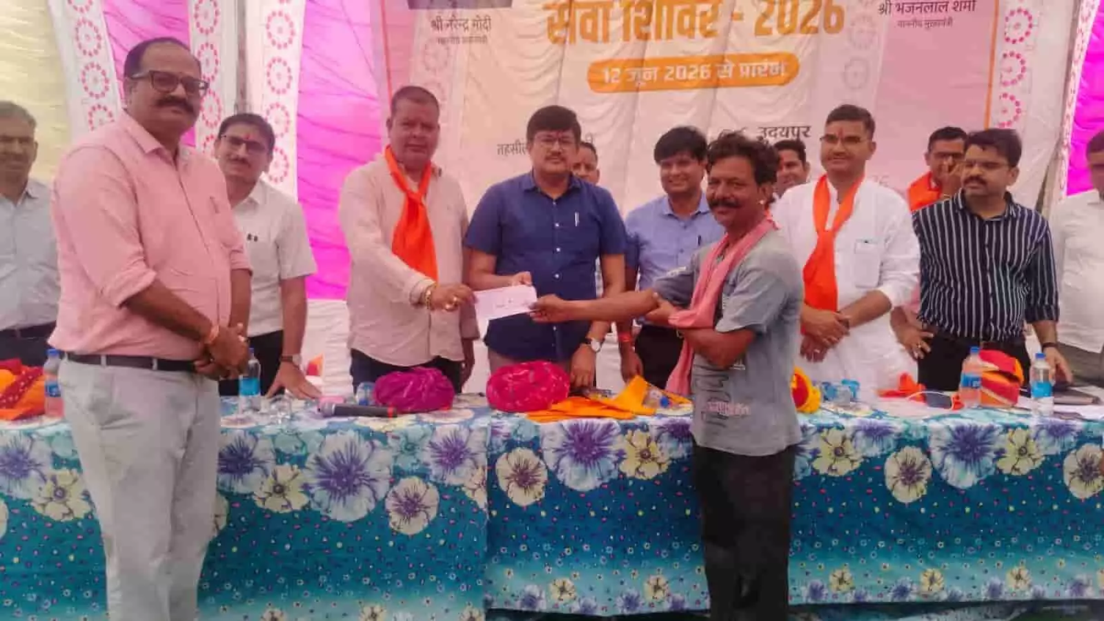 मंच पर उपस्थित प्रशासनिक अधिकारी और जनप्रतिनिधि एक नागरिक को वित्तीय सहायता का चेक सौंपते हुए। मंच पर उपस्थित प्रशासनिक अधिकारी और जनप्रतिनिधि एक नागरिक को वित्तीय सहायता का चेक सौंपते हुए।