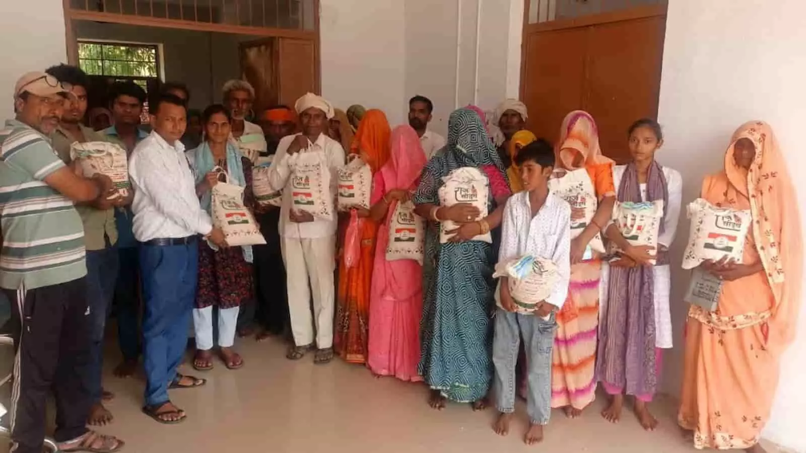 तस्वीर में कृषि विभाग के अधिकारी और ग्रामीण जवास गांव में बीज के मिनीकिट पैकेट थामे खड़े दिख रहे हैं।
